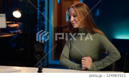 Young girl using smartphone selfie camera to film content for her online fans, talking about gen Z topics. Joyful person recording vlog for internet channel with cellphone, camera A 124063521