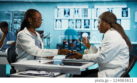 African american girl paying for prescribed pills and medicaments on POS terminal, purchasing painkillers and vitamins directly from the medical cabinet. Health care practice. Camera B. African american girl paying for prescribed pills and medicaments on POS terminal, purchasing painkillers and vitamins directly from the medical cabinet. Health care practice. Camera B. 124063611