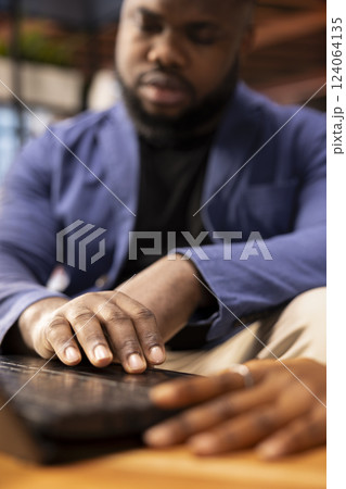 Black couple in their living room discusses creative ideas for an online business, using modern technology to research trends and improve efficiency. Motivation and support for success. Close up. 124064135