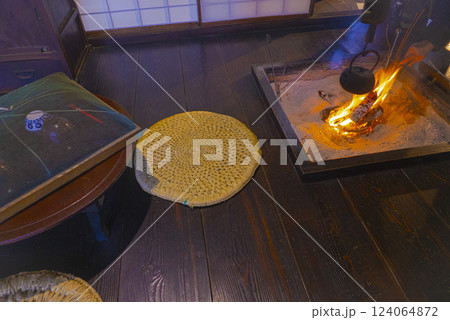 雰囲気のある古民家の囲炉裏の火の様子を見る男性の手の写真 雰囲気のある古民家の囲炉裏の火の様子を見る男性の手の写真 124064872