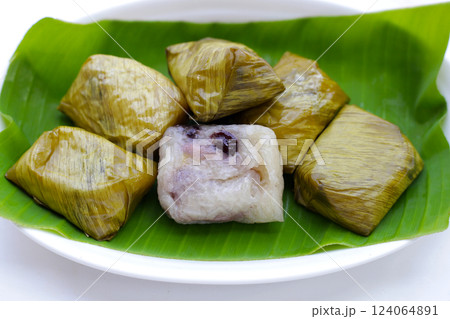 Bundled boiled sticky rice with banana and black beans wrapped in banana leaves Bundled boiled sticky rice with banana and black beans wrapped in banana leaves 124064891