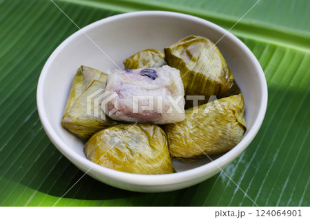 Bundled boiled sticky rice with banana and black beans wrapped in banana leaves Bundled boiled sticky rice with banana and black beans wrapped in banana leaves 124064901