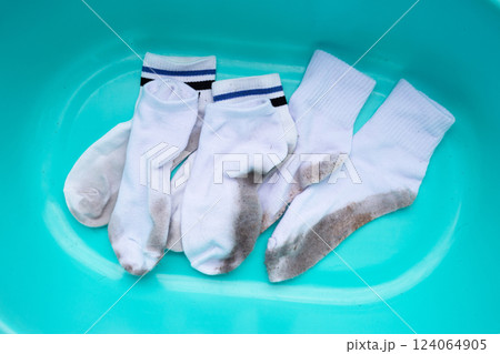 Dirty white socks in blue basin 124064905