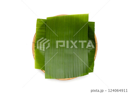 Banana leaves in bamboo weave plate on white background. Banana leaves in bamboo weave plate on white background. 124064911