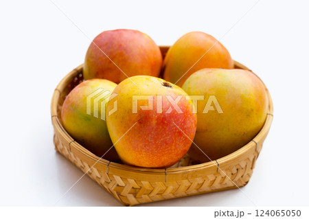 Mango in bamboo basket on white background. Tropical fruit Mango in bamboo basket on white background. Tropical fruit 124065050