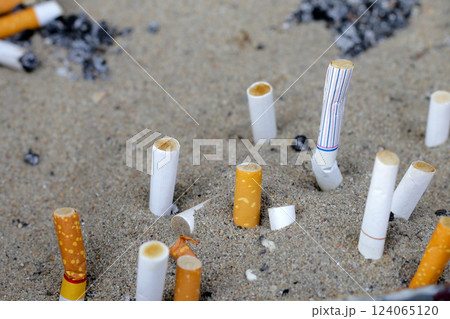 Cigarettes and ash on dirty sand in trash tray 124065120