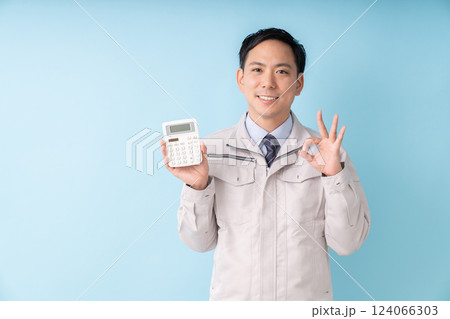 電卓を持つ笑顔の男性　ビジネス　作業服 124066303