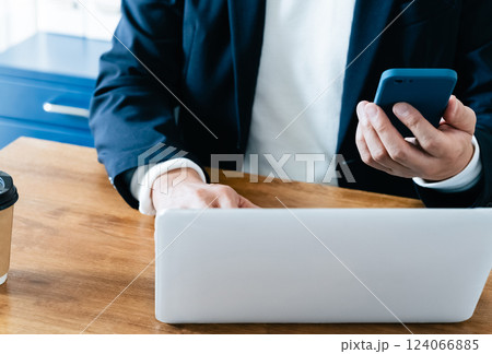 パソコンとスマホを操作する男性 124066885
