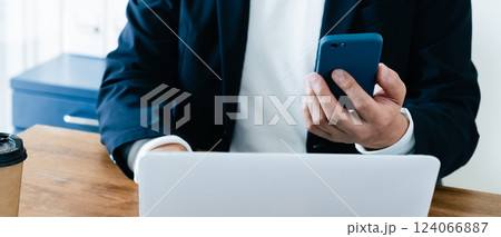 パソコンとスマホを操作する男性 124066887