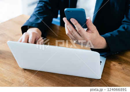パソコンとスマホを操作する男性 124066891