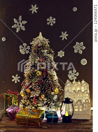 Decorated new year tree, small gifts and crafted house made of paper. Merry Christmas and Happy Holidays greeting card. Winter background with xmas symbols. Decorated new year tree, small gifts and crafted house made of paper. Merry Christmas and Happy Holidays greeting card. Winter background with xmas symbols. 124066971