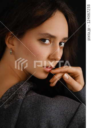 Close-up portrait of Caucasian woman with brown hair and dark eyes. Looking at camera. Close-up portrait of Caucasian woman with brown hair and dark eyes. Looking at camera. 124067258