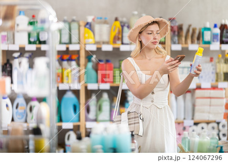 Girl buyer scans qr code on mosquito repellent label Girl buyer scans qr code on mosquito repellent label 124067296