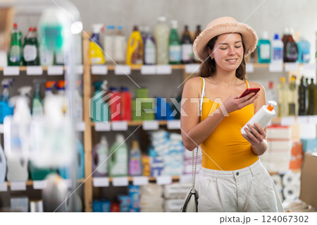 Girl buyer scans qr code on sunblock cream label Girl buyer scans qr code on sunblock cream label 124067302