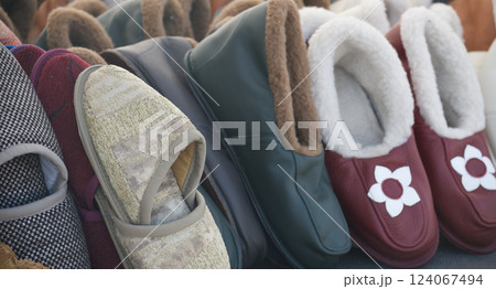 Collection of cozy slippers in various colors and styles, offering comfort and warmth 124067494