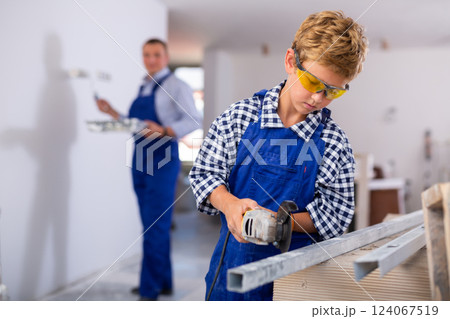Boy renovating home with father, cutting profile 124067519
