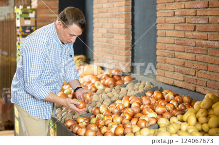 Male customer made beeline for fresh produce section, pick up onion for morning salad 124067673