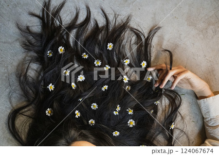 Woman black hair decorated with daisy flowers 124067674