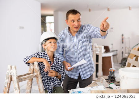 Father and son talking about space planning in new apartment 124068053
