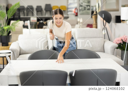Girl buyer choose dining table desk in furniture store showroom 124068102
