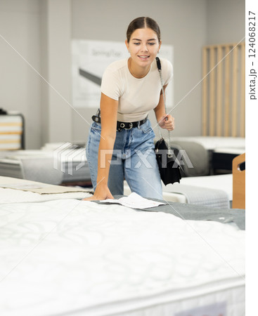 Woman in furniture center chooses best sofa for her apartment Woman in furniture center chooses best sofa for her apartment 124068217