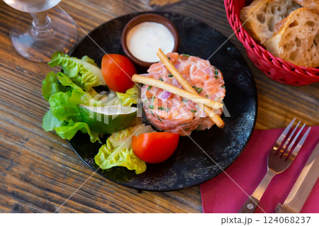 Salmon tartare with chive cream, vegetables, lime and breadsticks Salmon tartare with chive cream, vegetables, lime and breadsticks 124068237