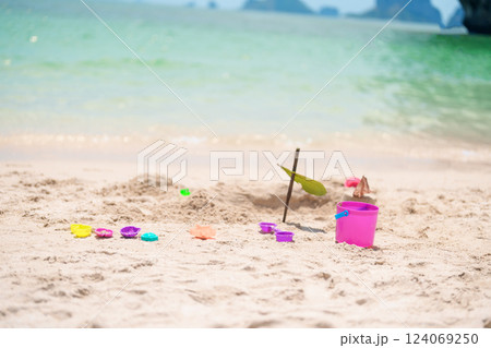 colourful beach toys on tropical beach, Children bucket, spade and other toys on beach against beautiful sea. Summertime and vacation Concept colourful beach toys on tropical beach, Children bucket, spade and other toys on beach against beautiful sea. Summertime and vacation Concept 124069250