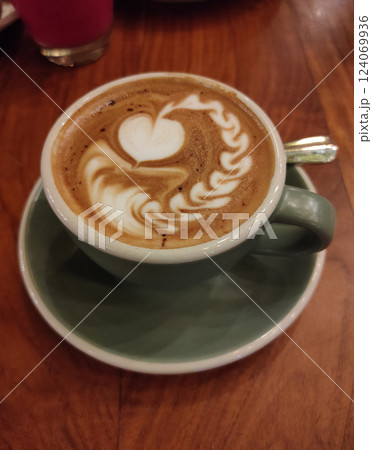 A cup of cappuccino on a wooden table. 124069936