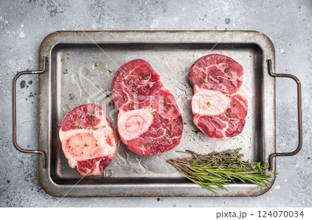 Raw ossobuco cuts, veal shank meat, the ultimate ingredient for rich stews and classic Italian comfort food delights. grey background. top view Raw ossobuco cuts, veal shank meat, the ultimate ingredient for rich stews and classic Italian comfort food delights. grey background. top view 124070034