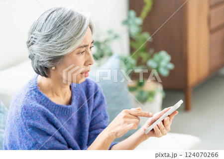 スマホを操作するシニア女性 124070266