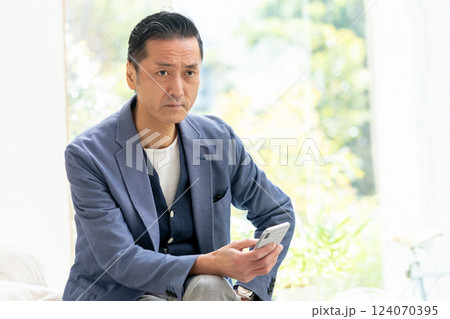 スマートフォンを操作するミドル男性 124070395
