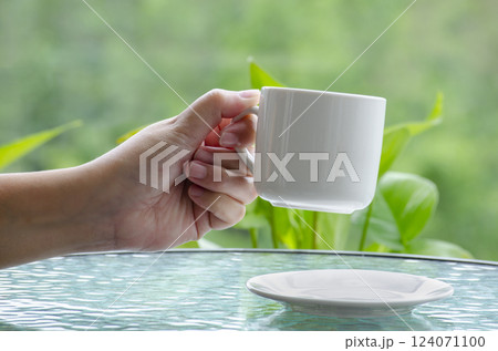 Hand holding a white cup with customizable space for mockup or text. Mockup concept. 124071100