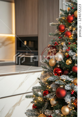 Decorated Christmas tree standing in modern kitchen interior 124072223