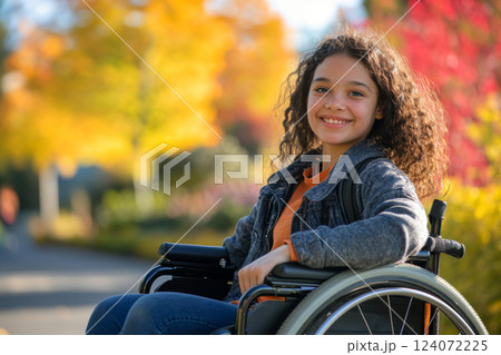 Smiling Child in Wheelchair Outdoors in Park 124072225