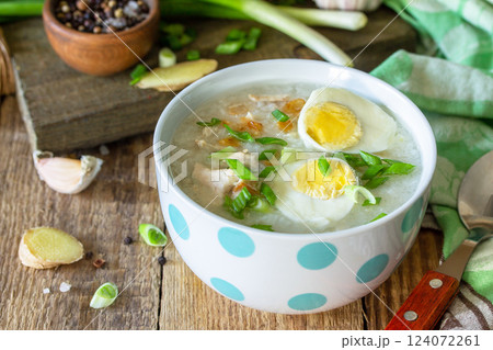 Hot soup chicken with ginger rice and garlic in a bowl on a rustic table. 124072261