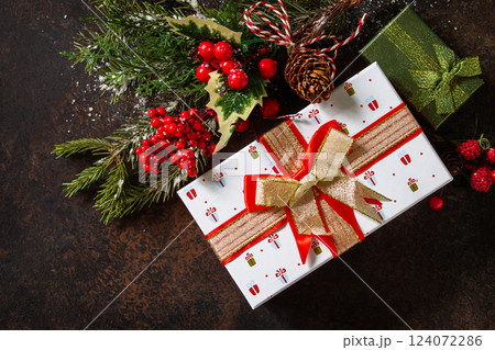 Christmas or New Year concept. Christmas presents gift red box and tree branch decor. Top view flat lay background. Christmas or New Year concept. Christmas presents gift red box and tree branch decor. Top view flat lay background. 124072286
