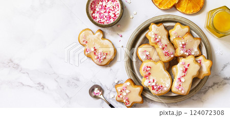 Christmas baking. Homemade gingerbread cookies with glaze on a marble countertop. Top view flat lay. Copy space. Christmas baking. Homemade gingerbread cookies with glaze on a marble countertop. Top view flat lay. Copy space. 124072308