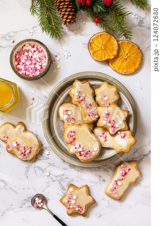 Christmas baking. Homemade gingerbread cookies with glaze on a marble countertop. Top view flat lay. Christmas baking. Homemade gingerbread cookies with glaze on a marble countertop. Top view flat lay. 124072680