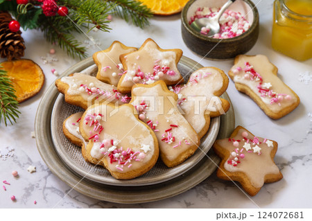 Christmas pastries. Homemade gingerbread cookies with glaze on a marble countertop. 124072681