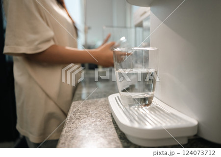A glass of clean drinking water on water purifier in a modern kitchen A glass of clean drinking water on water purifier in a modern kitchen 124073712