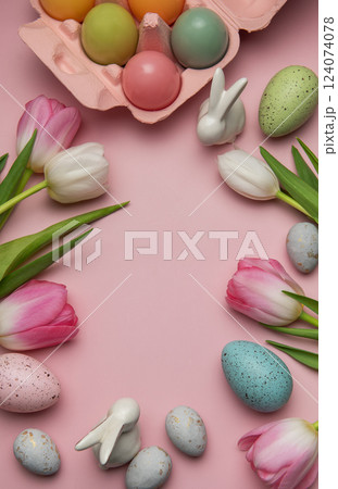 Easter eggs, ceramic bunnies and tulips creating a frame on pink background 124074078