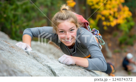 Climber scaling rocky terrain in vibrant autumn forest during outdoor adventure 124074372