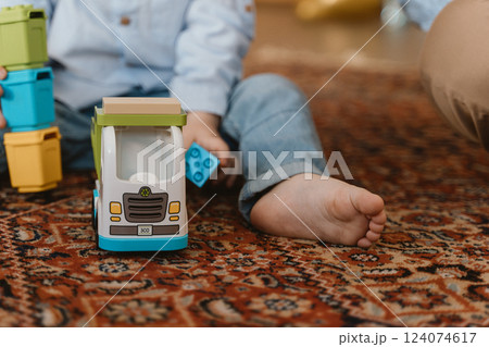 Child Playing with Toy Truck on Carpet Child Playing with Toy Truck on Carpet 124074617