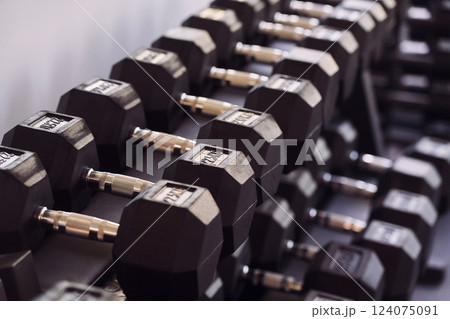 Close up view of dumbbells that laying down on the stand in the gym 124075091