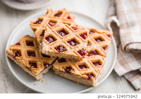 Sweet linzer cake on plate on kitchen table. 124075842