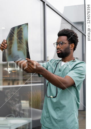 Man doctor examines X-ray scan in clinic 124076394