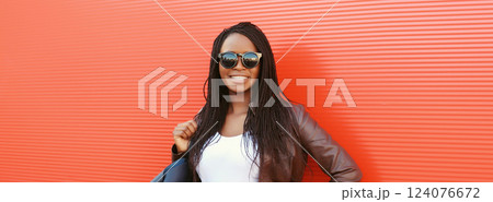 Fashionable happy young African woman with handbag in casual, stylish black girl posing in the city Fashionable happy young African woman with handbag in casual, stylish black girl posing in the city 124076672