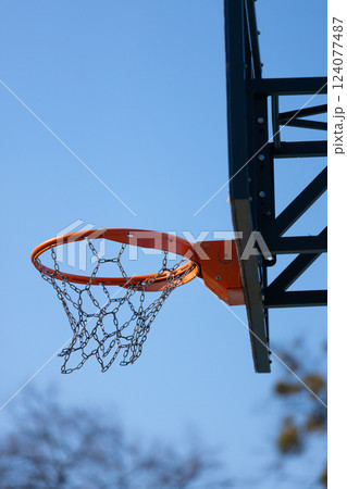 A Vibrant Basketball Hoop Against a Clear Blue Sky, Capturing the Essence of Outdoor Sports and Recreation in a Bright and Cheerful Atmosphere for All Ages and Skill Levels A Vibrant Basketball Hoop Against a Clear Blue Sky, Capturing the Essence of Outdoor Sports and Recreation in a Bright and Cheerful Atmosphere for All Ages and Skill Levels 124077487