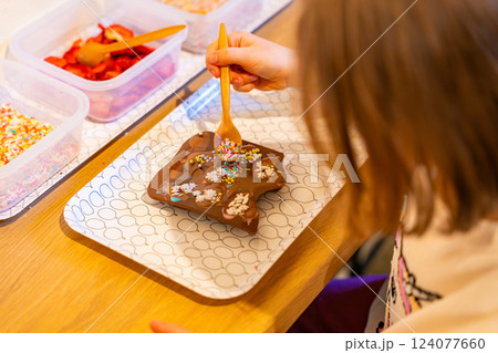 Little girl making chocolate candies at the Chocolate Museum in Prague. A hands-on experience showcasing traditional chocolate-making techniques Little girl making chocolate candies at the Chocolate Museum in Prague. A hands-on experience showcasing traditional chocolate-making techniques 124077660