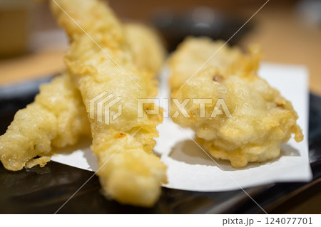 Crispy shrimp tempura with a golden, airy batter served on a black plate Crispy shrimp tempura with a golden, airy batter served on a black plate 124077701